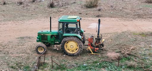 A view of an abandoned old green tractor in the field that was used to work in agriculture