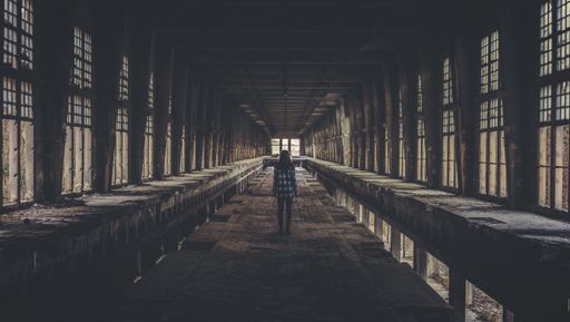 A young female standing inside an old abandoned building