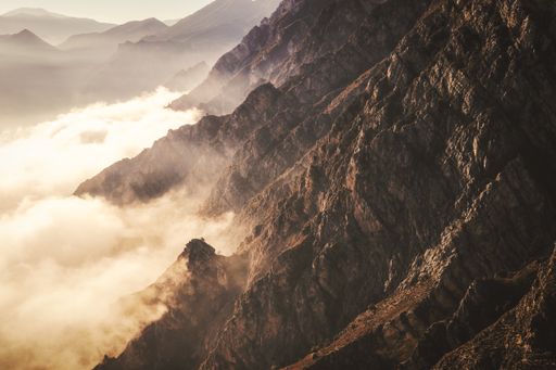 A closeup shot of beautiful rocky mountains covered in fog