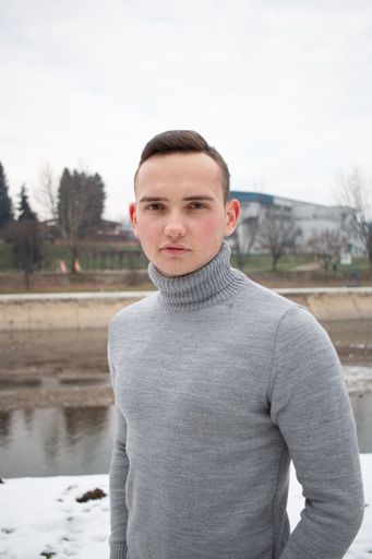 A closeup of a man in a turtleneck posing for a photo
