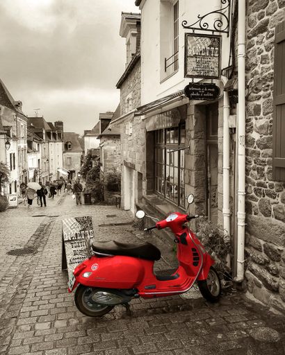 A vertical shot of a scooter parked up in a typical French street