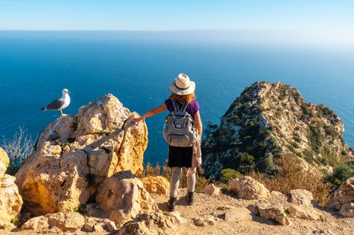 A closeup of a young hiker at the Mirador de Carabineros in the Penon de Ifach Natural Park in Spain