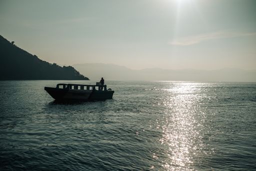 A scenic view of a boat sailing in Lake Atitlan in Guatemala on a sunny day