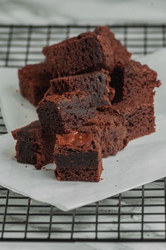 A vertical closeup of delicious brownies on the napkin.