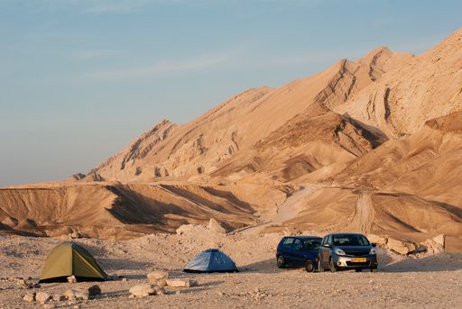 Camping in a wadi in the judean desert in Israel, cars standing beside tents, tourism near the dead sea, arava area