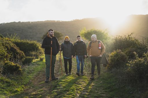 A group of friends walking along the green route during the hike in the peak of La sierra, Andaluza