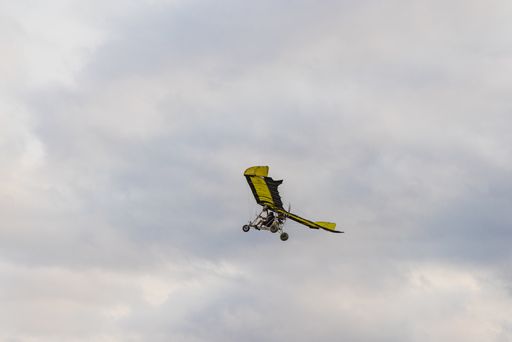 A closeup of a Small light aircraft flying in a cloudy sky