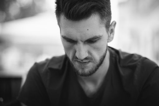A closeup of a male model looking down at something expressing anger or disappointment
