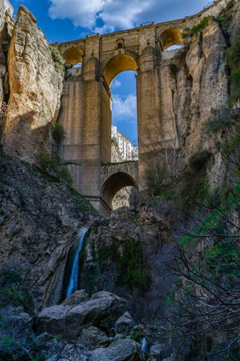 view from below the new bridge of ronda, malaga, spain, known as the tajo de ronda, view of the bridge and the waterfall.