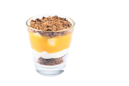 A closeup shot of a mascarpone curd dessert with cookies in a glass isolated on a white background