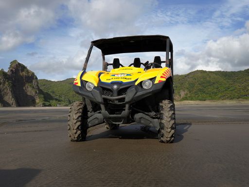 View of surf lifeguard life saving yellow Yamaha utility ROV vehicle at Karekare beach. Lafesaving club.