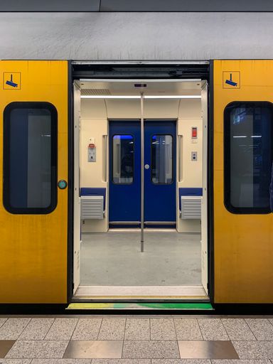 A vertical shot of an empty metro doors open revealing passengers in Amsterdam, Netherlands