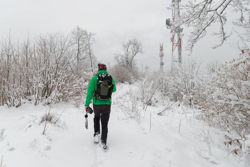 A man in a hiking outfit in the snowy woods
