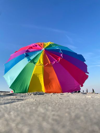 A colorful beach umbrella in the sand on Tybee Island, Georgia