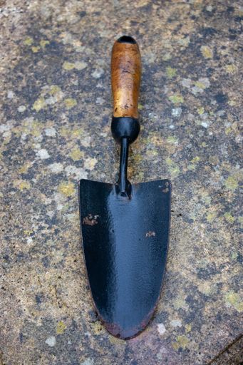 A vertical shot of a small shovel on a tile surface