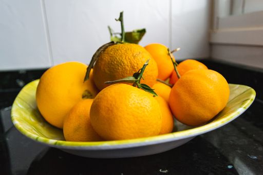 A closeup shot of fresh tangerines in a green plate