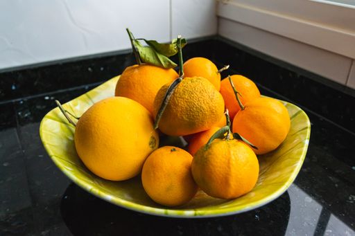 A closeup shot of fresh tangerines in a green plate