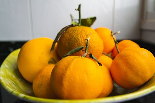 A closeup shot of fresh tangerines in a green plate