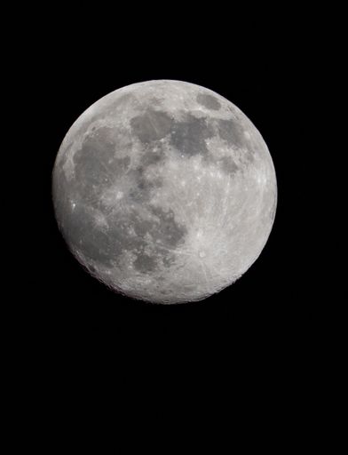 vertical photo of full moon on black background