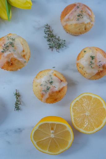 A vertical closeup shot of a delicious sweet lemon muffins on a white table