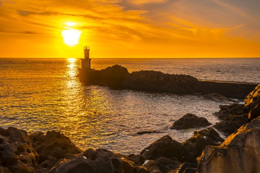 A lighthouse during a beautiful orange sunset in the Pasajes San Juan, Gipuzkoa, Spain