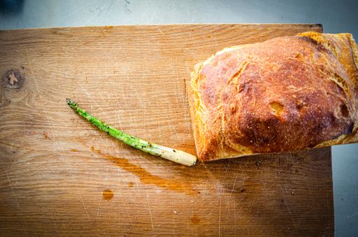 A high angle shot of the bread with asparagus on a wooden board