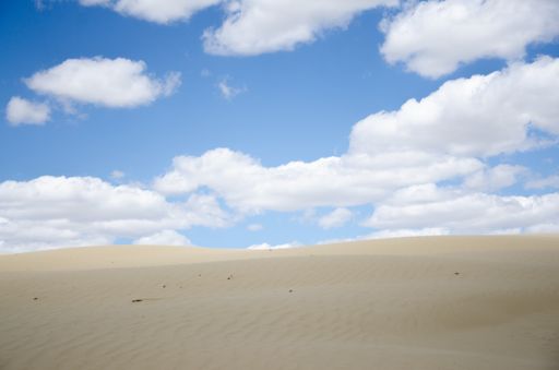 The desert hills gleaming under the beautiful blue cloudy sky