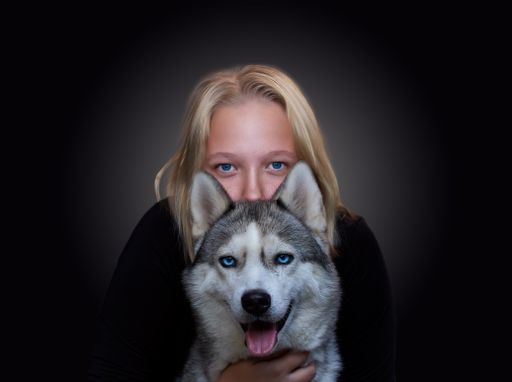 A Russian girl and a dog with blue eyes on a dark background