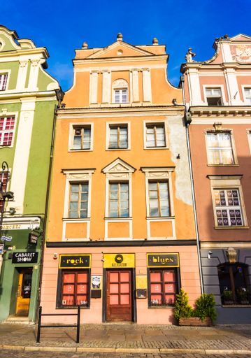 Front entrance of the Alligator club inside a colorful high building in the old city square