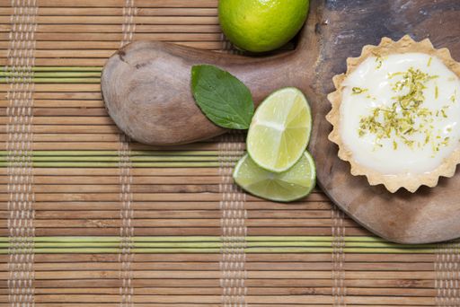 White cream and a lime served on the wooden tray on the bamboo rolling mat