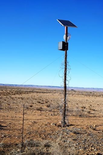 A vertical shot of an electric power pole in a desert in South Africa