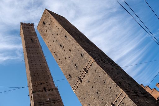A low angle shot of the magnificent Towers of Bologna captured under the blue sky in Bologna, Italy