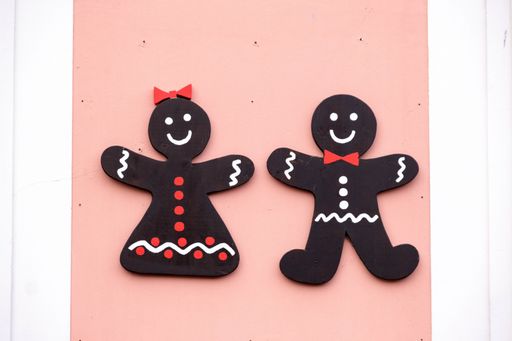 A high angle shot of handcrafted cardboard looking like two people on a pink surface