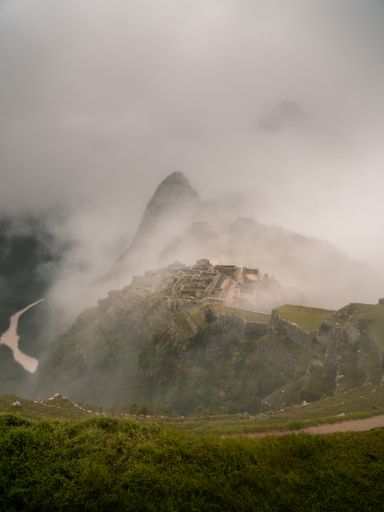 A vertical shot of a mysterious mountain surrounded with fog