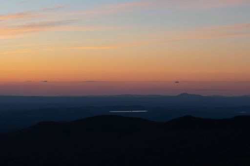 A scenic view of hills against a colorful cloudy sky during a sunset