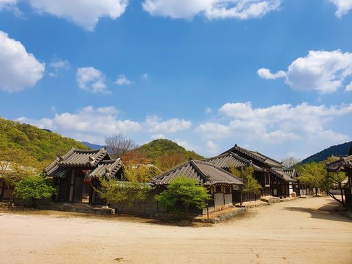 A pathway in the middle of Korean village buildings under a blue sky