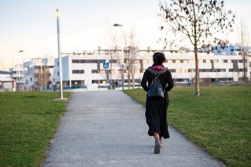 A back view of a stylish woman walking on the pathway in the park