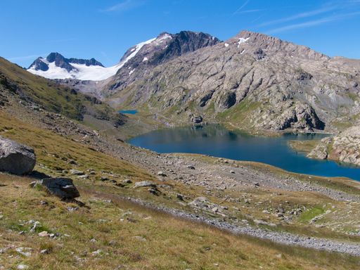 A view of a beautiful green valley with hills and a pond in Col de la Croix de Fer, Savoie, France