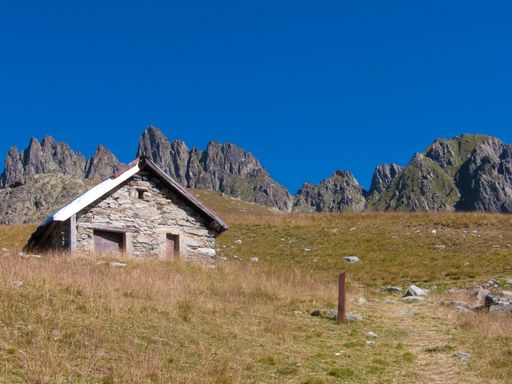 A low angle shot of a small house near cliffs in in Lac de la Combe, Haute Savoie, France