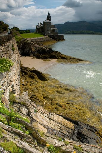 A vertical shot of the beautiful castle on the shore of the lake in Wales, UK.