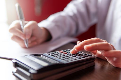 Woman writing and using a calculator,  businesswoman or student. Working from home concept, copy spa