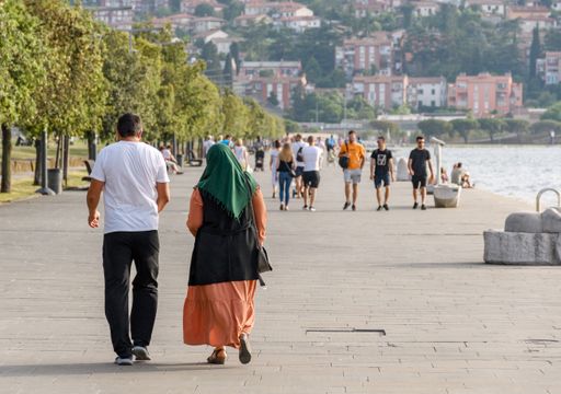 The diverse people walking on the waterfront promenade in Koper, Slovenia.