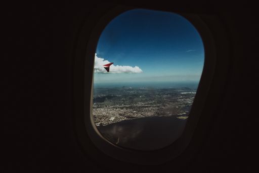 A horizontal shot of the sky and the city from, taken from an airplane porthole