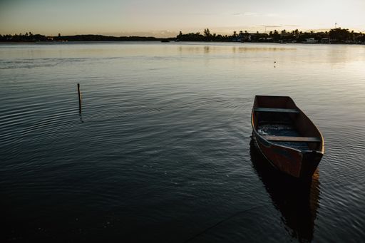 A horizontal shot of a small rowboat standing still in a serene lake