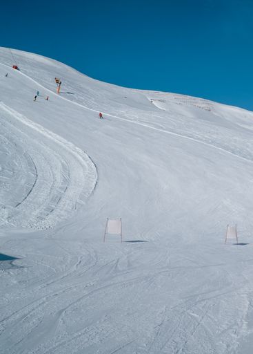 A vertical view of skiers skiing down slopes in the ski resort of Livigno, Italy
