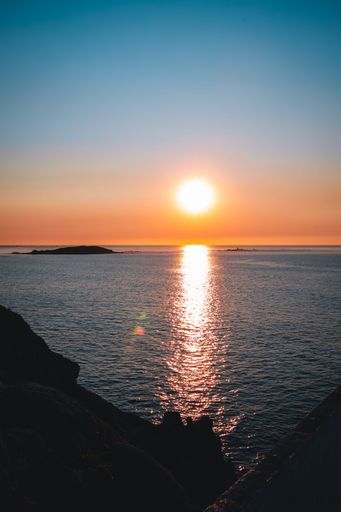 A vertical shot of a beautiful view over the rocks to the sea during sunset