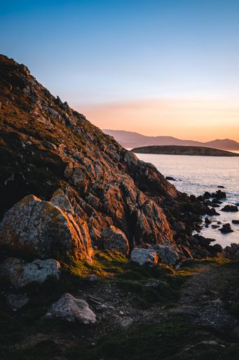 A vertical shot of a beautiful view over the rocks to the sea during sunset