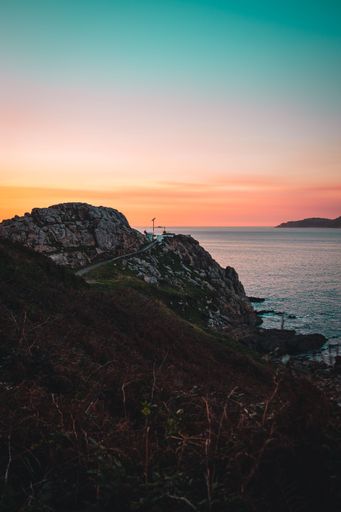 A vertical shot of a beautiful view over the rocks to the sea during sunset