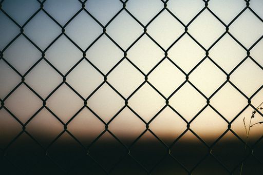 A horizontal shot of a metallic fence with the background blurred