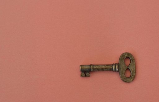 The Lonely Small old metal key on the pink background